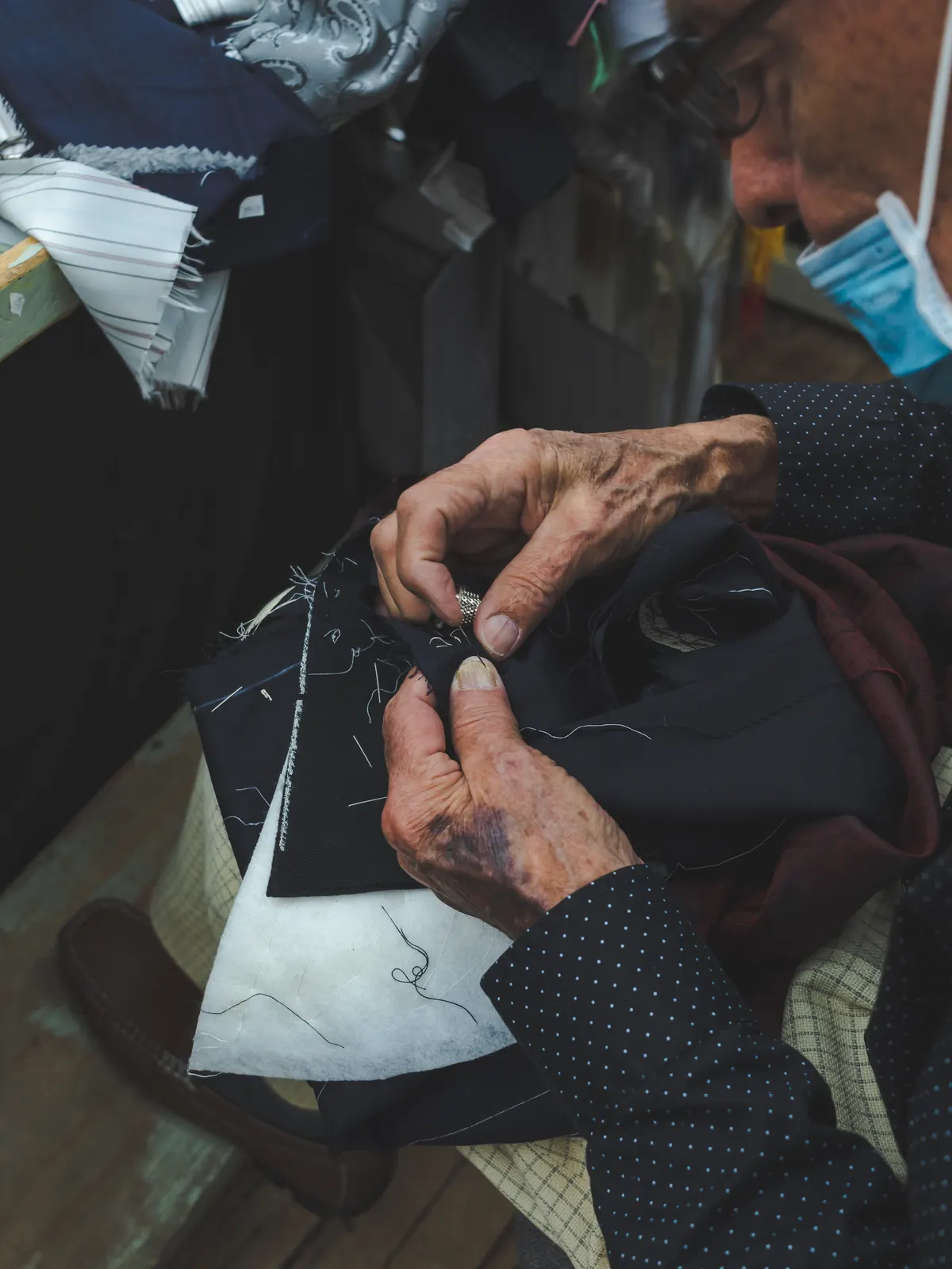 Hands working on a garment at a bench
