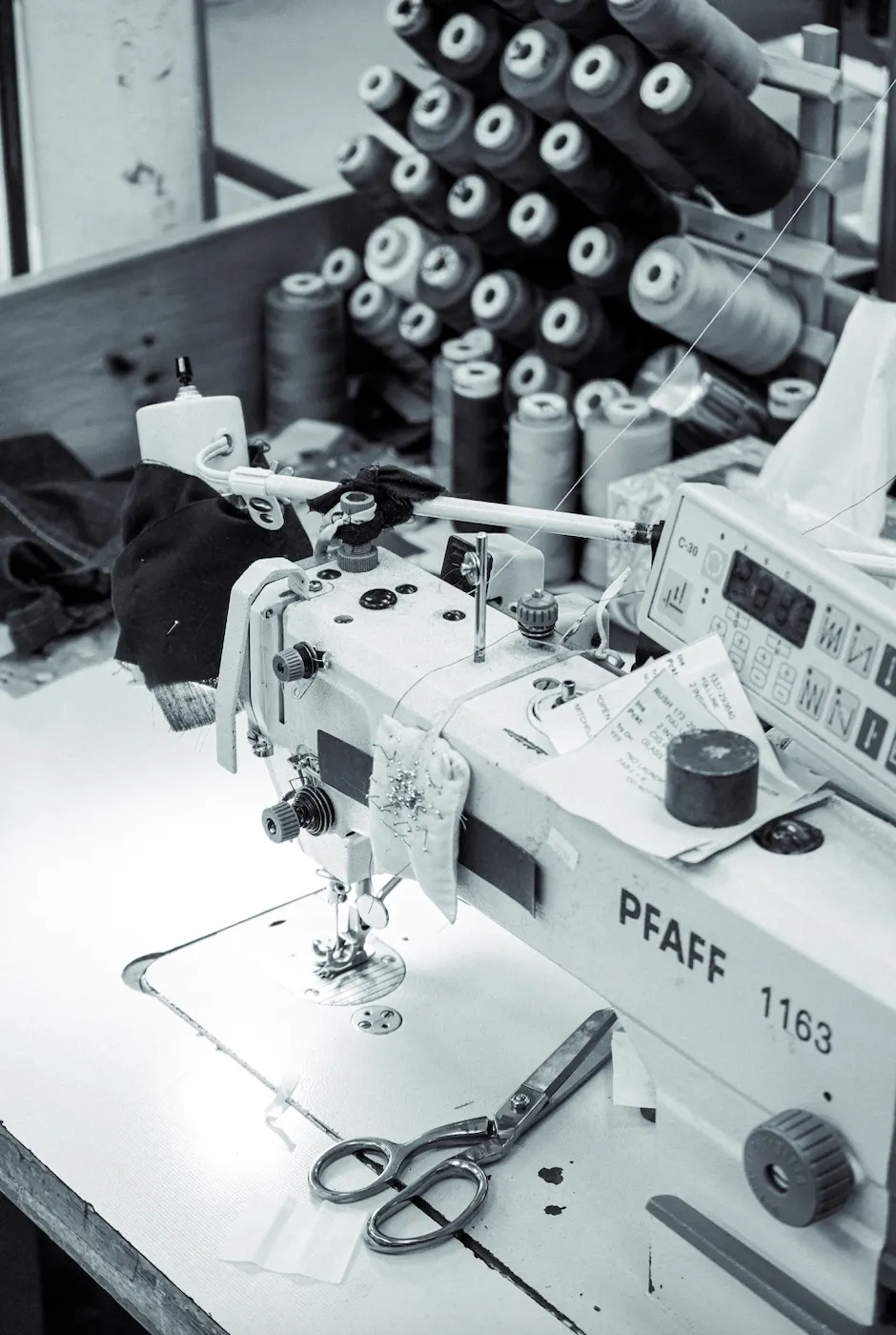 Industrial sewing machine with spools of black thread