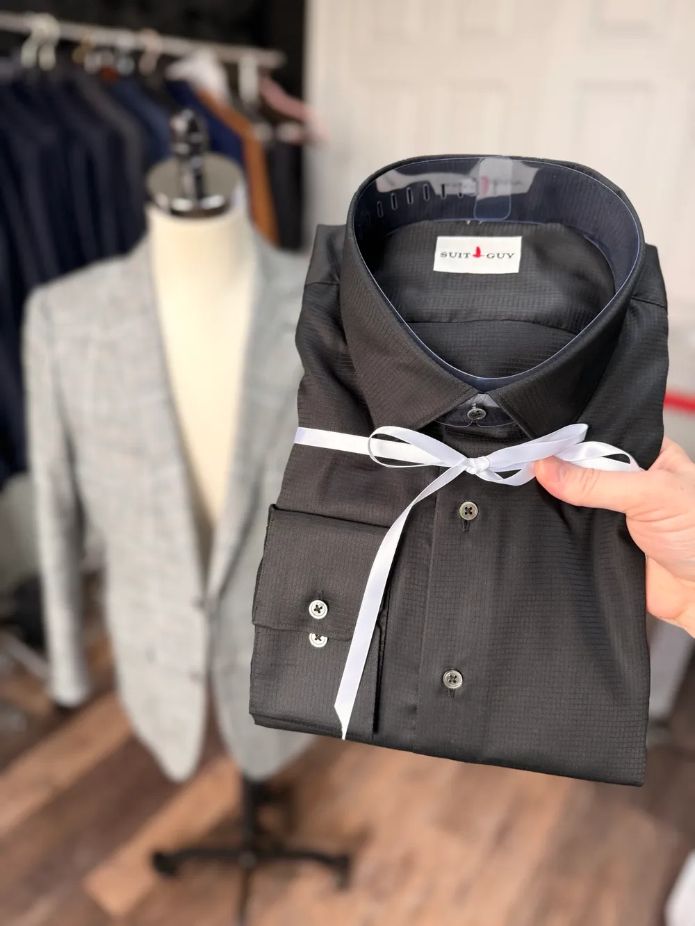 A black custom shirt folded and tied with white ribbon