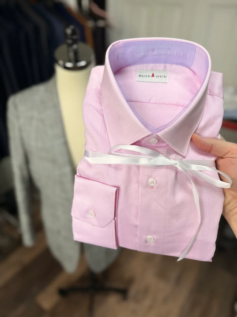 A pink check shirt folded and tied with white ribbon
