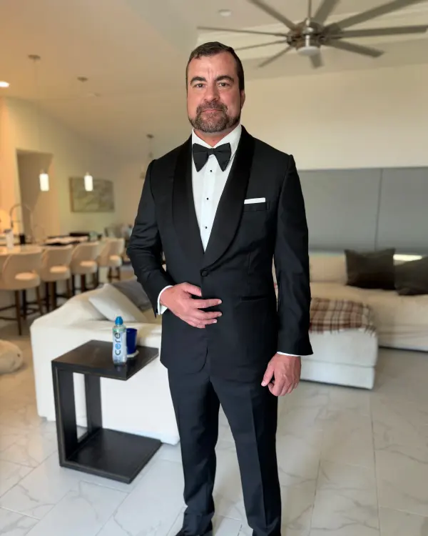 A groom in a custom black suit and bow tie
