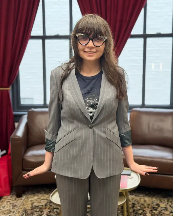 A woman in a custom gray pinstripe suit