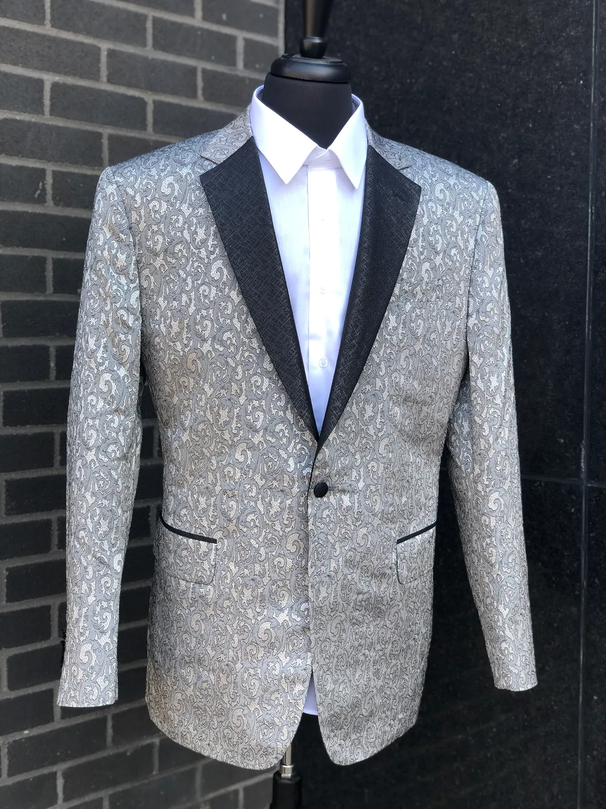 A custom silver jacquard tuxedo jacket with black textured peak lapels, made for a red-carpet event