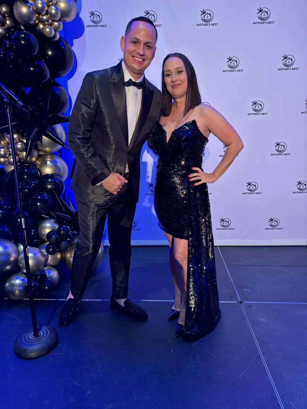 A man in a one-of-a-kind custom metallic black tuxedo with satin lapels and studded loafers at a red-carpet gala in Naples