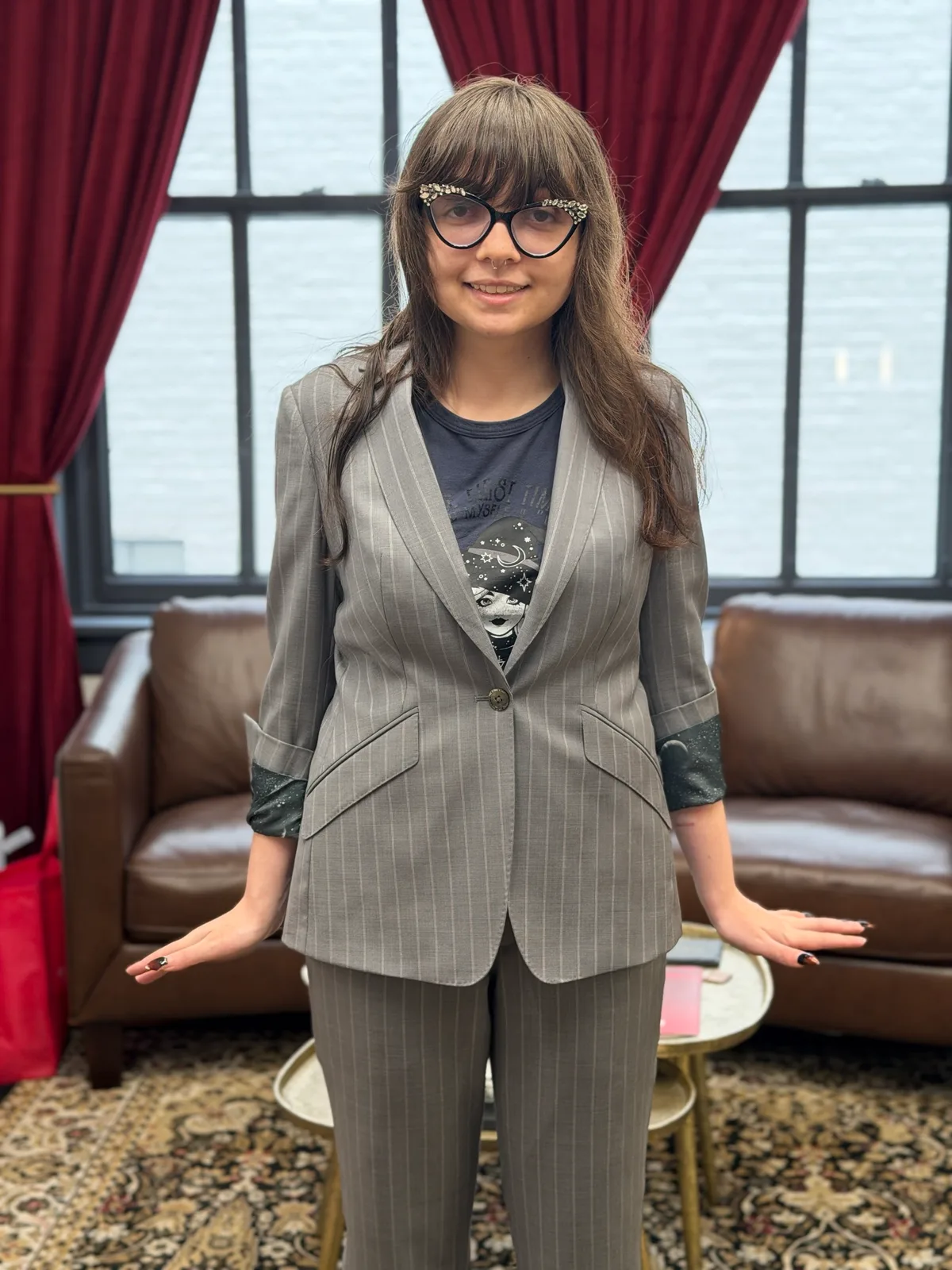 A woman in a custom gray pinstripe jacket and wide-leg trousers, with a star-and-moon print on the cuff lining