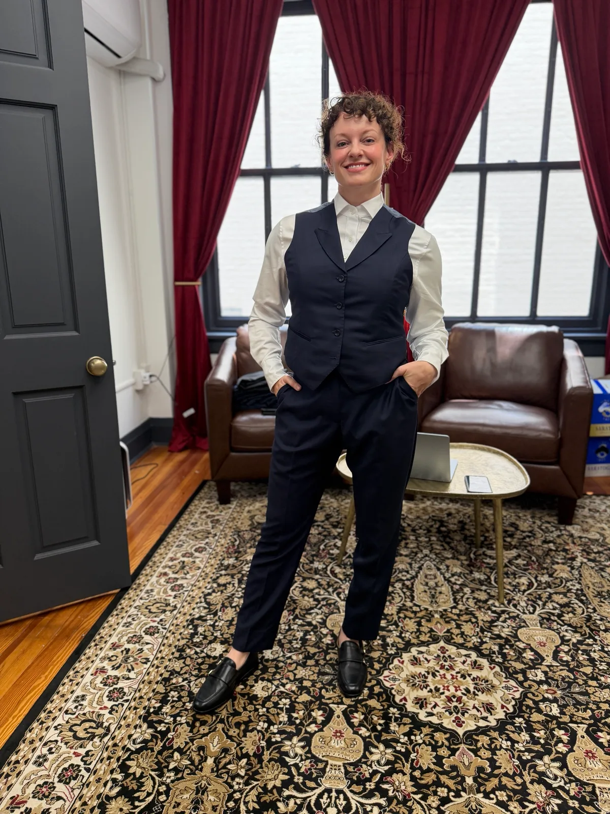 A woman in a custom navy vest and trousers over a white shirt